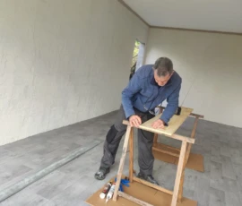 Fred le gérant, fabriquant un meubles malins dans sont atelier